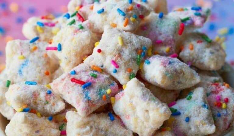 Cake Batter Puppy Chow in a bowl with rainbow sprinkles