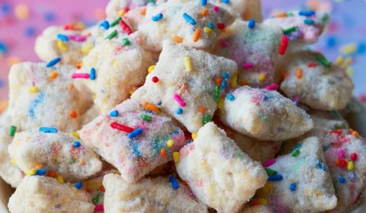 Cake Batter Puppy Chow in a bowl with rainbow sprinkles