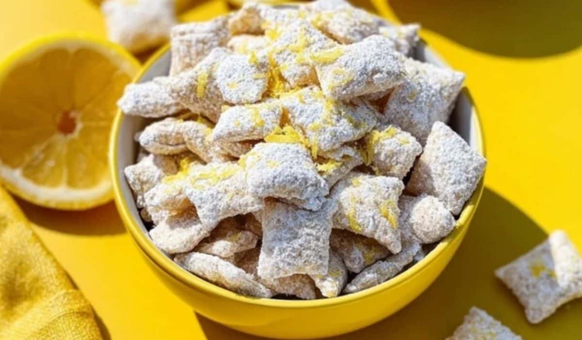 Zesty Lemonade Puppy Chow Snack bowl with lemon zest and powdered sugar