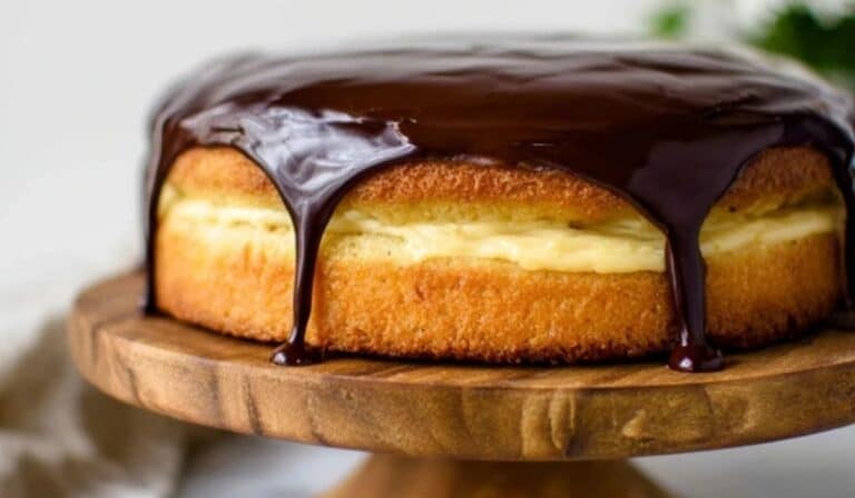 Boston Cream Pie on cake stand with chocolate glaze