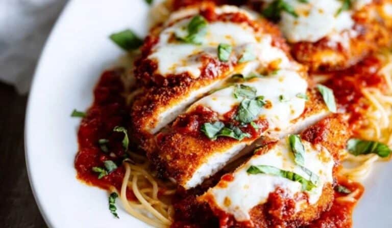 Baked chicken parmesan recipe with golden crispy cutlets and melted cheese on platter