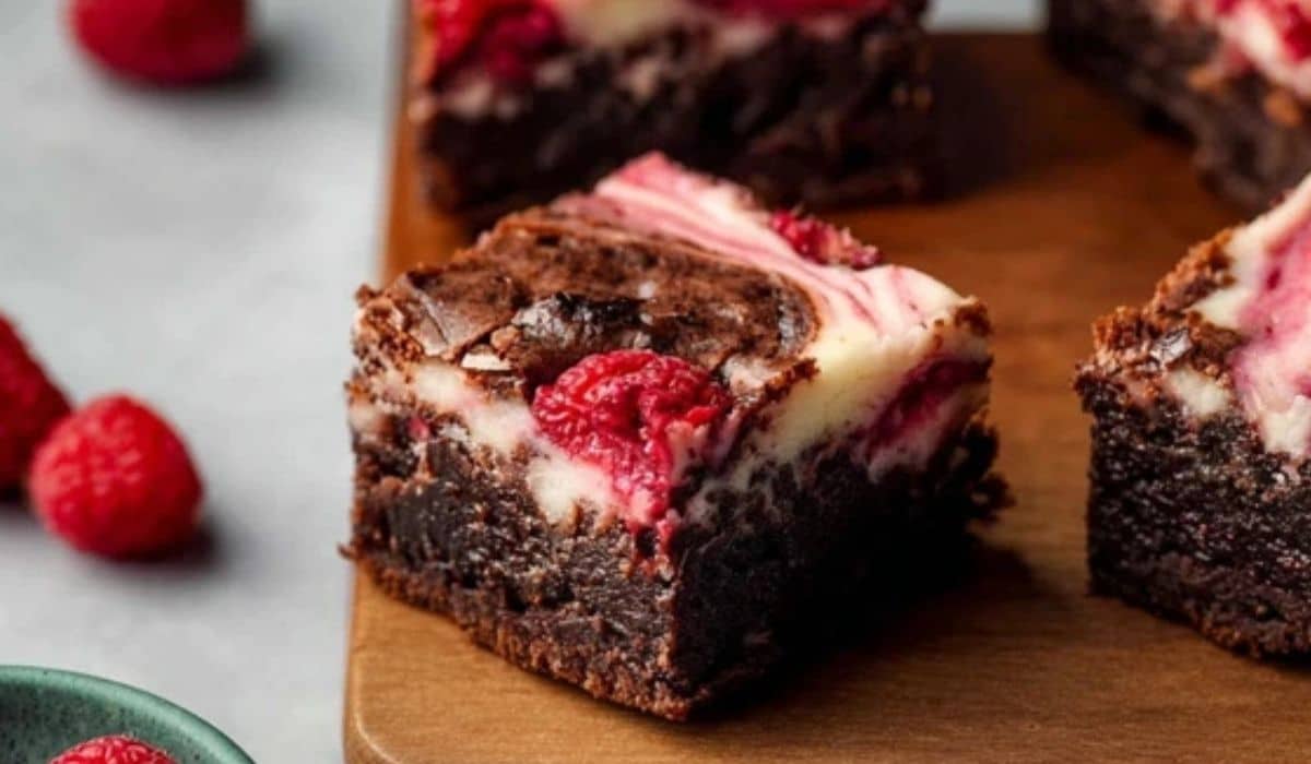 raspberry cheesecake brownies on wooden board