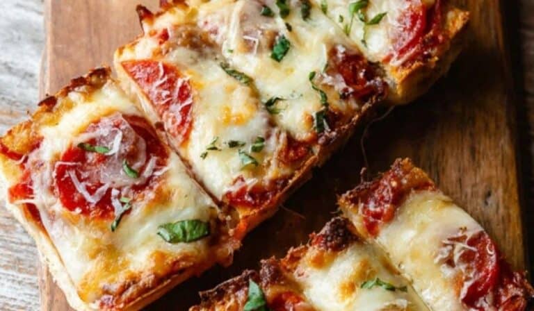 French Bread Pizza Recipe on baking sheet with melted cheese and pepperoni
