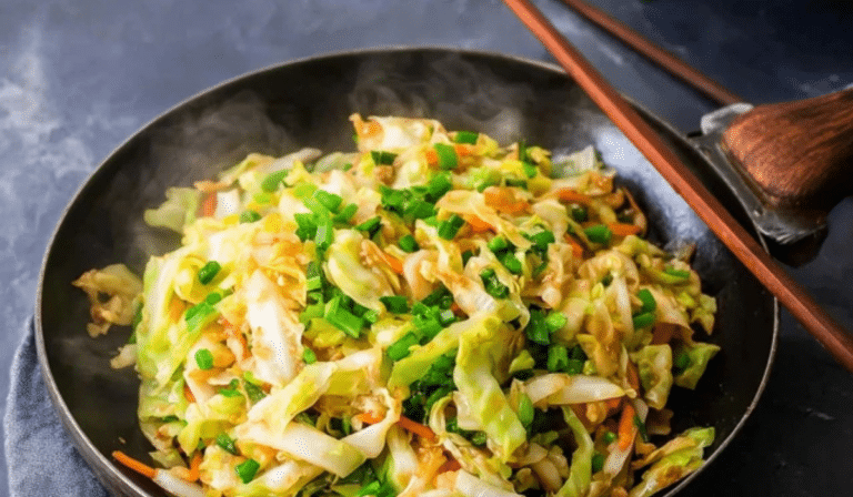 Cabbage Stir Fry in a wok with glossy sauce and garlic