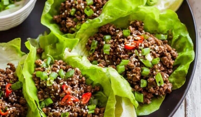 Ground beef lettuce wraps with sesame, scallions, and lime on a platter