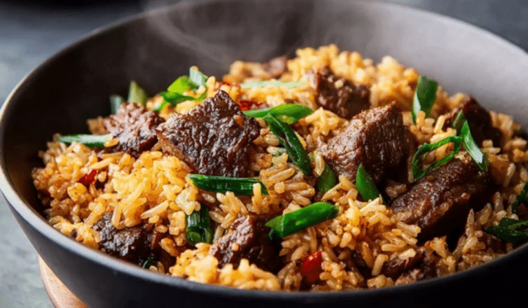 Sizzling Beef Steak Fried Rice in a wok with tender steak and scallions