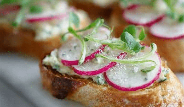 Spring Radish Crostini with creamy Herb Butter on a platter with sliced radishes and herbs