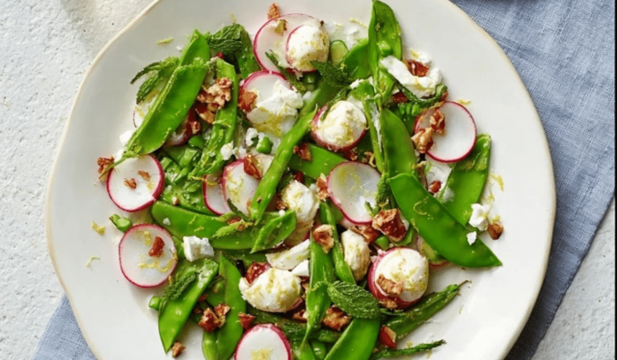 Minty snap pea salad with radishes, feta, and lemon zest on a platter