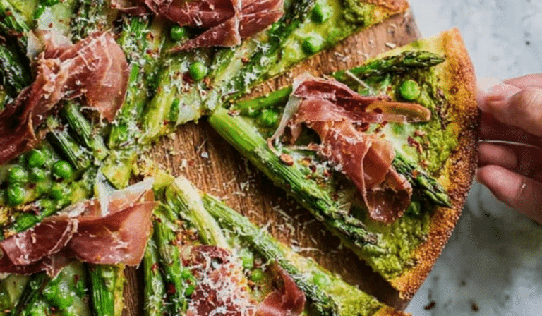 Asparagus Pizza with Green Pea & Prosciutto sliced on a board