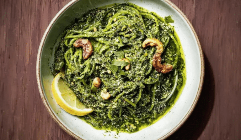 Pesto with Herb and Nut Swaps in a bowl with fresh herbs and toasted nuts